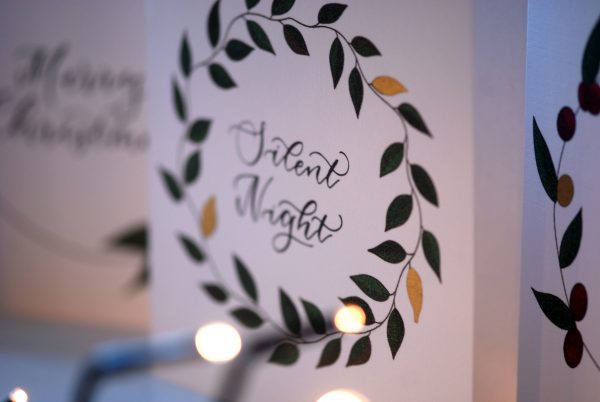 Luxury christmas card with leaf wreath design and gold accents with Silent Night phrase