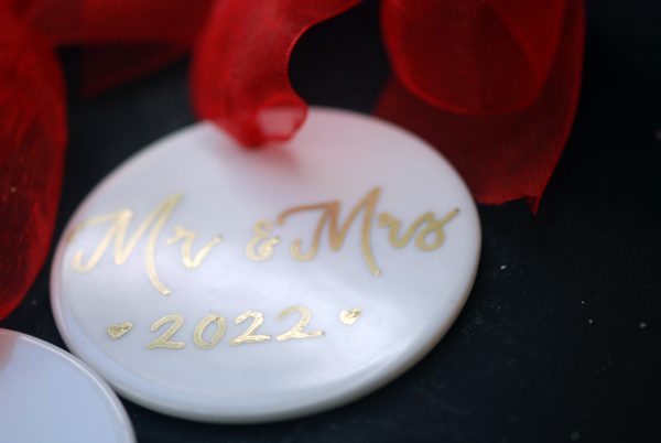 Close up of Personalised porcelain baubles with gold ink for christmas tree for married couple
